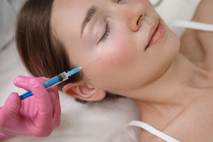 Cropped close up of a woman getting cheek filler injections at beauty clinic